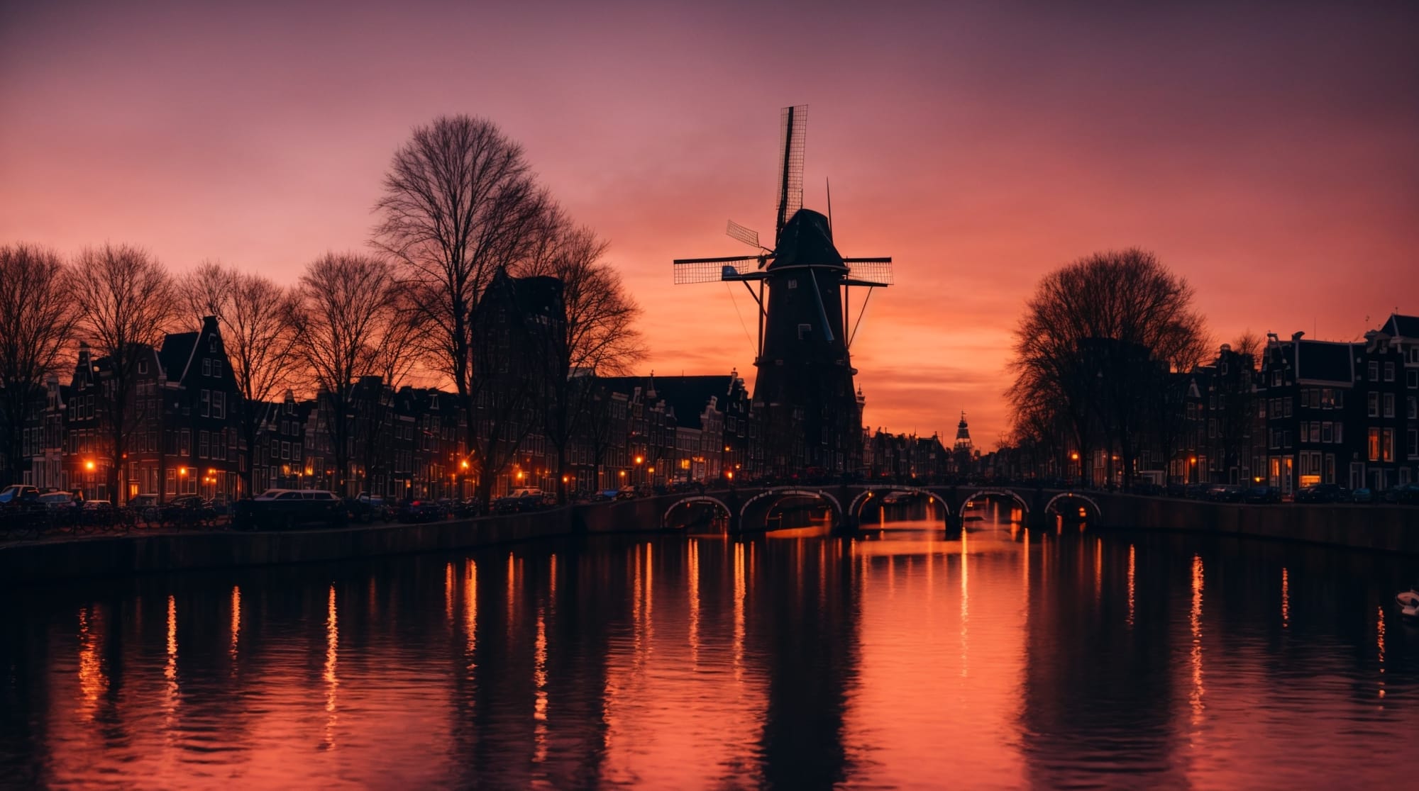 city tours sunset view of Amsterdam canal reflecting city lights, silhouette of a windmill in the distance