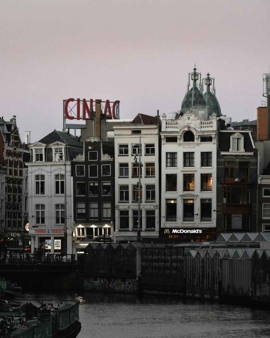 A scenic view of Amsterdam’s canals lined with historic houses and boats
