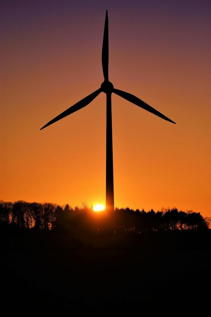 A scenic view of traditional Dutch windmills along a canal at sunset, capturing the essence of Dutch rural heritage.